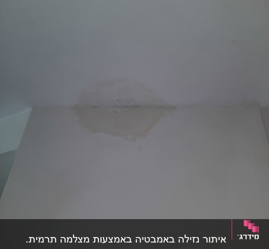 כתם רטיבות על תקרה לבנה